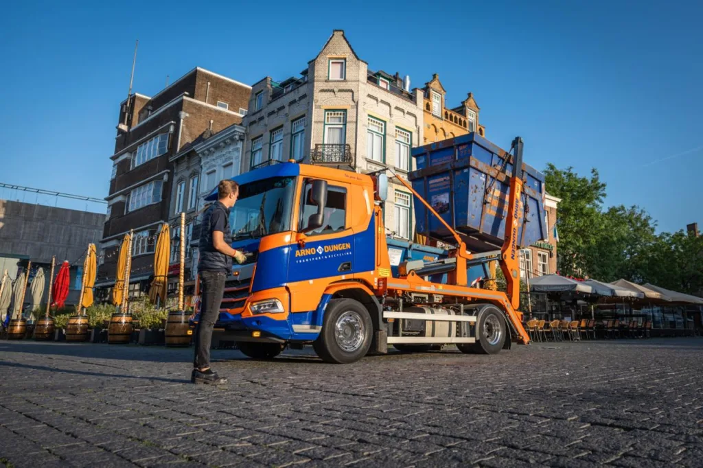 Portaalwagen die net een container optilt van de straat